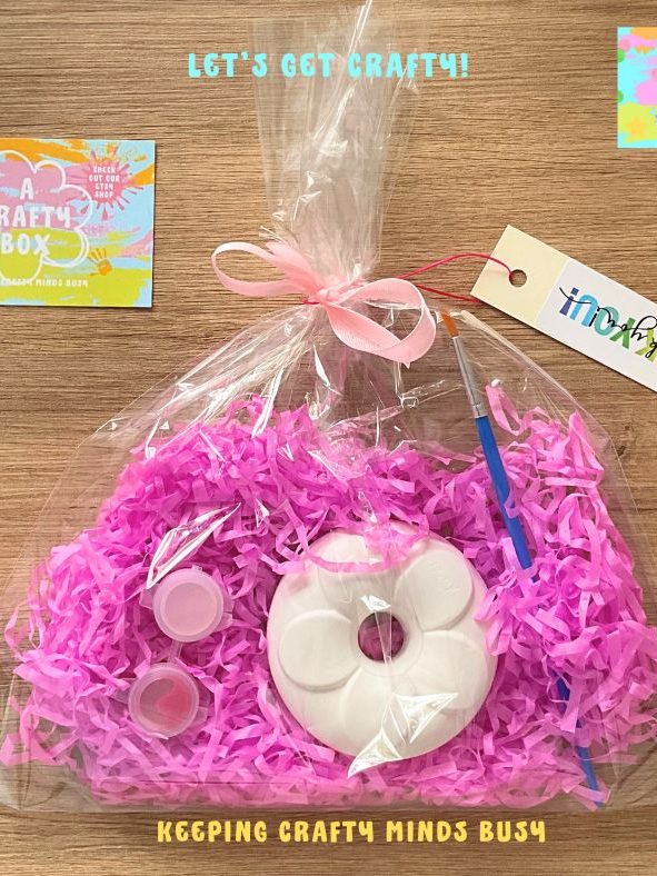 Party filler bag, donut mould inside see through bag. Pink tissue paper tied with pink bow. 