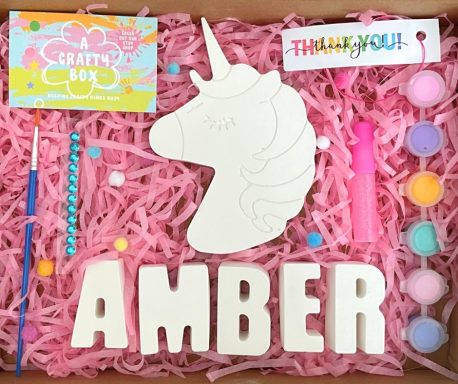 Large plaster of Paris unicorn, six paints paintbrush, Gem stickers glue and pom-poms.
