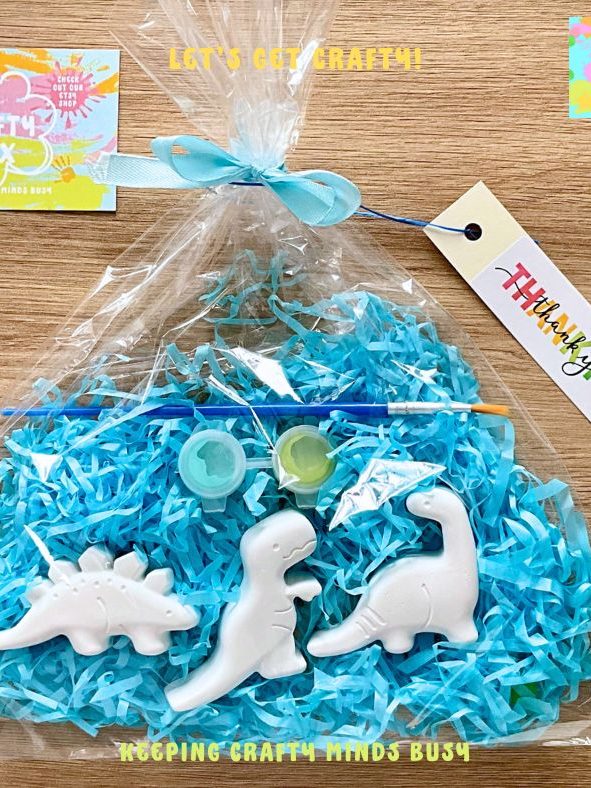 Three dinos, in a see through bag tied with a blue bow. Blue tissue paper inside. 
